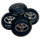 Four Toyota logo car wheel hub caps on a white background
